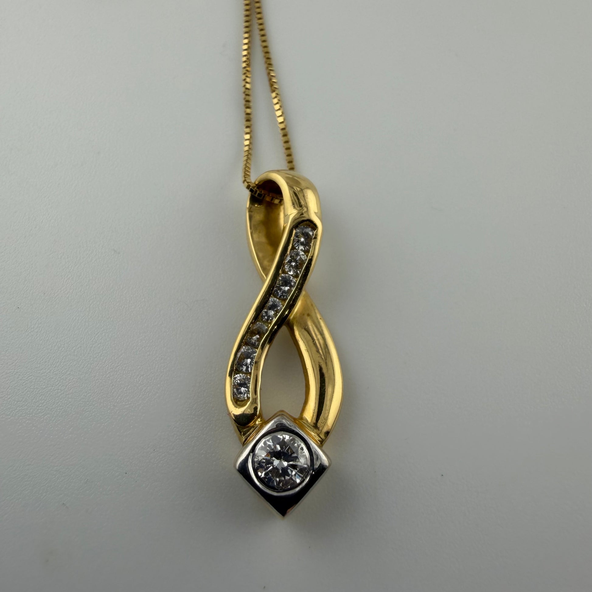 18ct gold 0.4ct diamond pendant on 18in box chain, hallmarked 4.1g, elegant twist design.