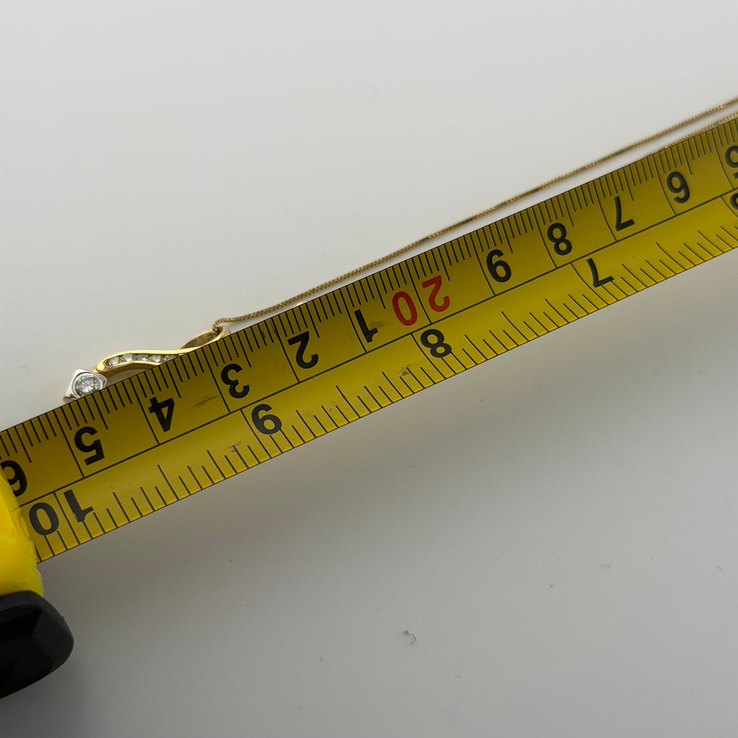 18ct gold 0.4ct diamond pendant on 18in box chain, hallmarked, 4.1g, with measuring tape showing length.