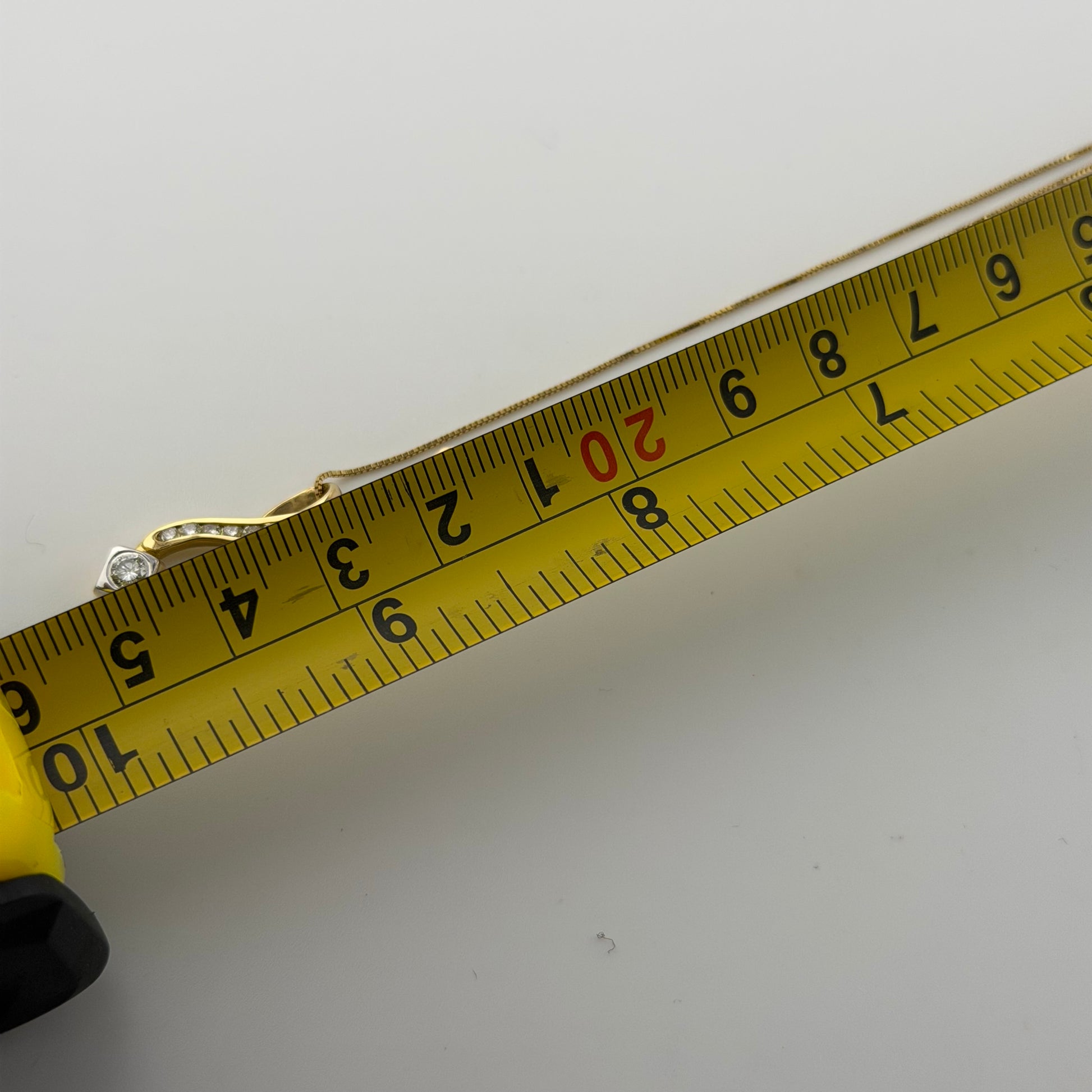 18ct gold 0.4ct diamond pendant on 18in box chain, hallmarked, 4.1g, with measuring tape showing length.